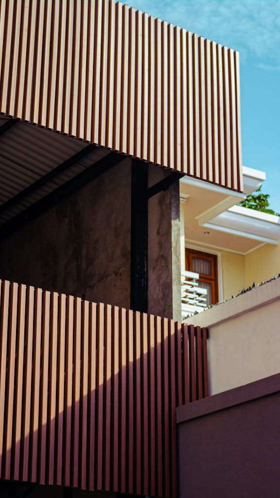 Contemporary building facade featuring wooden slats and angular design elements against a clear sky.